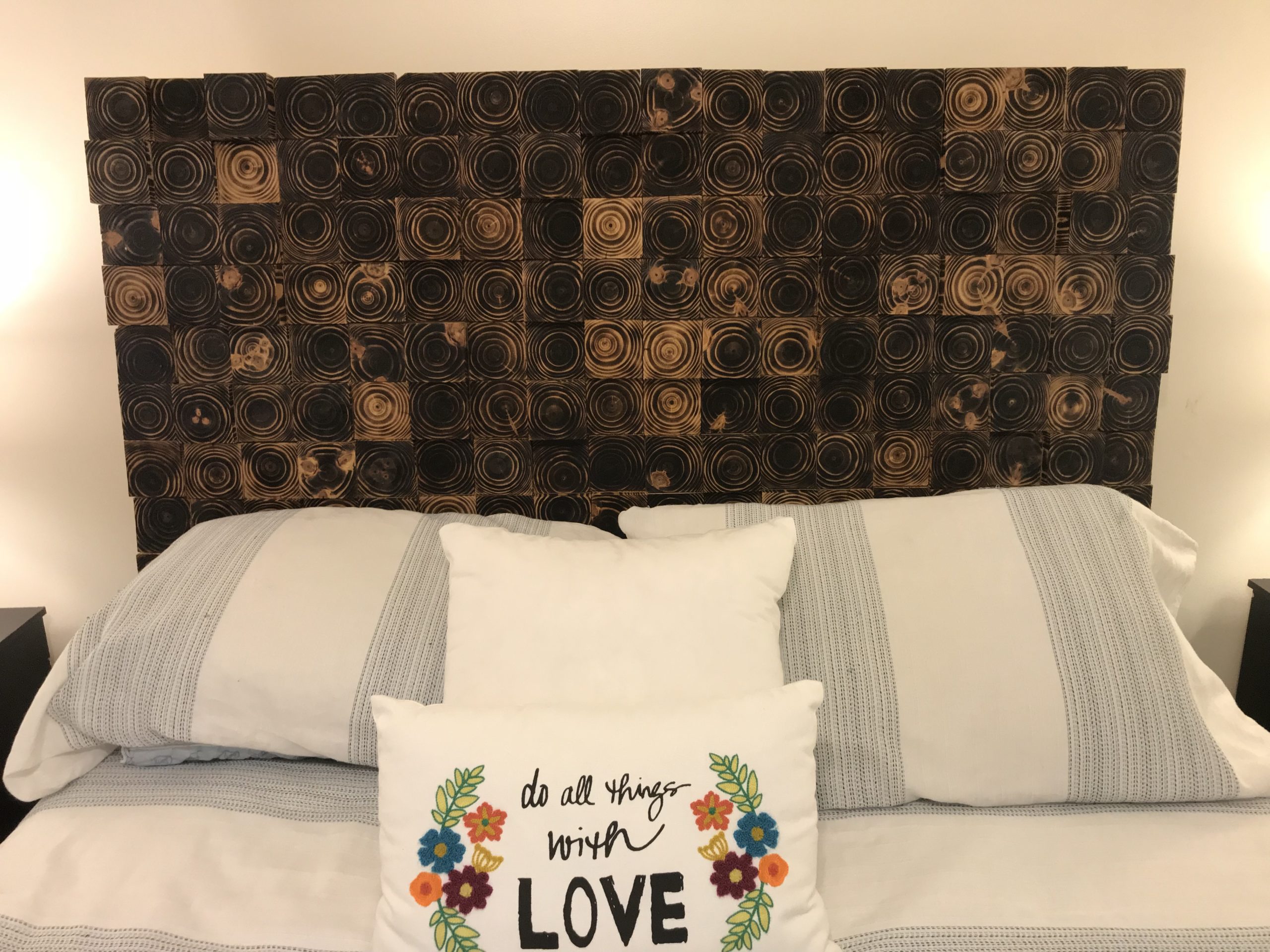 Headboard made of a collage of log cross-sections