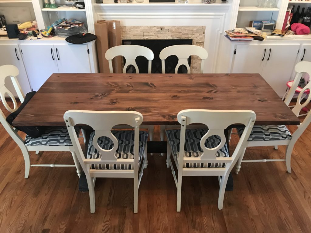 Wooden table with white chairs