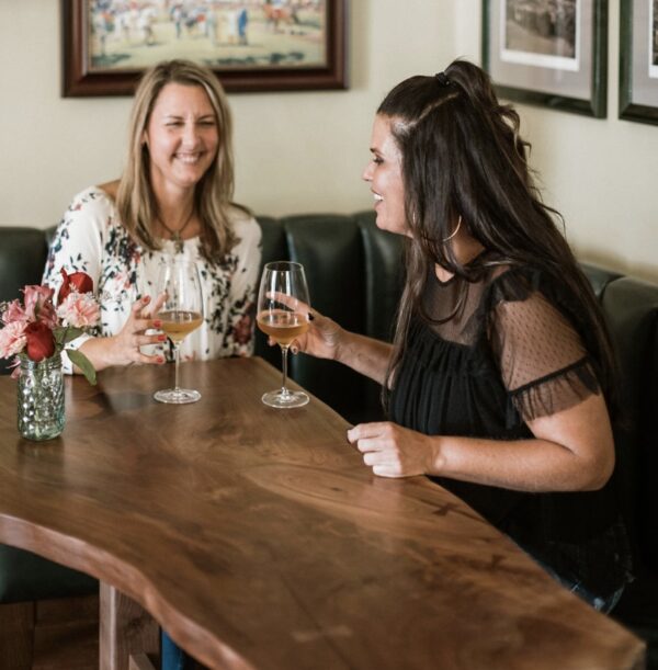 image of two woman drinking cocktails at a custom cocktail table